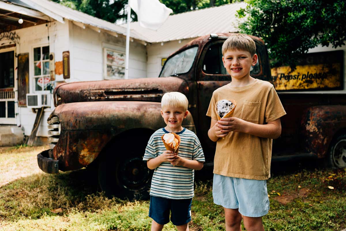 Two young brothers eating ice cream outside the Dixie Country Store.